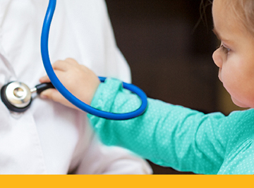 young child playing with stethoscope