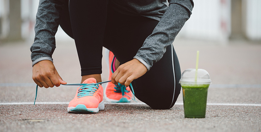 fit woman getting tying shoe laces and getting ready to run