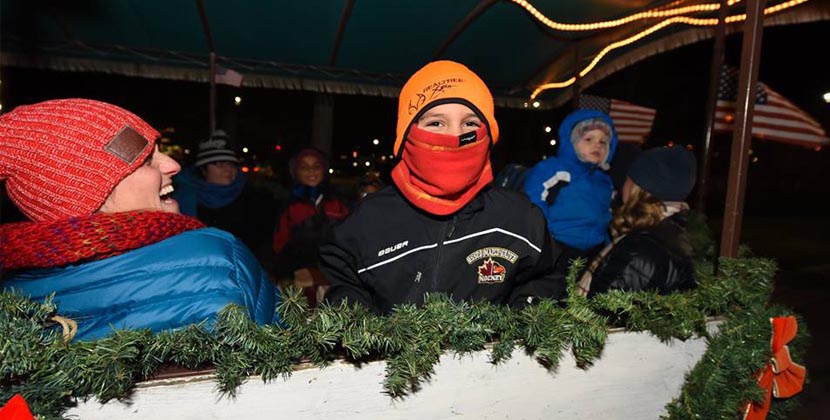 Young boy with face mask on during holiday trolley ride