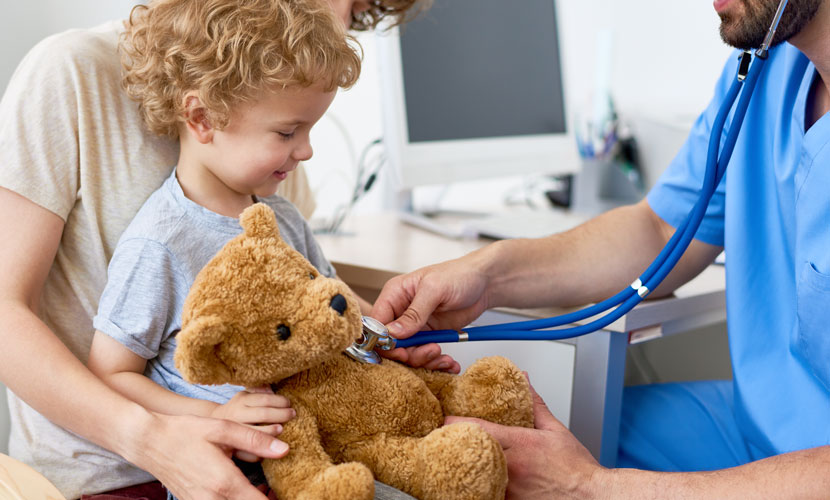 doctor with stethoscope on teddy bear with kid